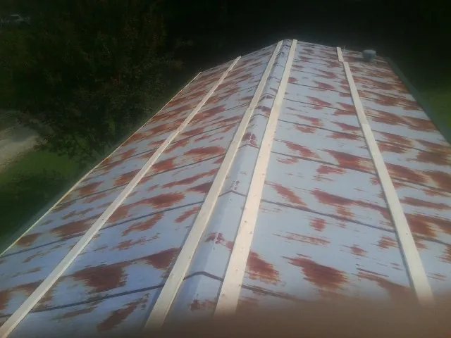 Rusted metal roof panels with new wood purlins before replacement — Storm Damage Roof Repair in Larimore by Roofing Brothers
