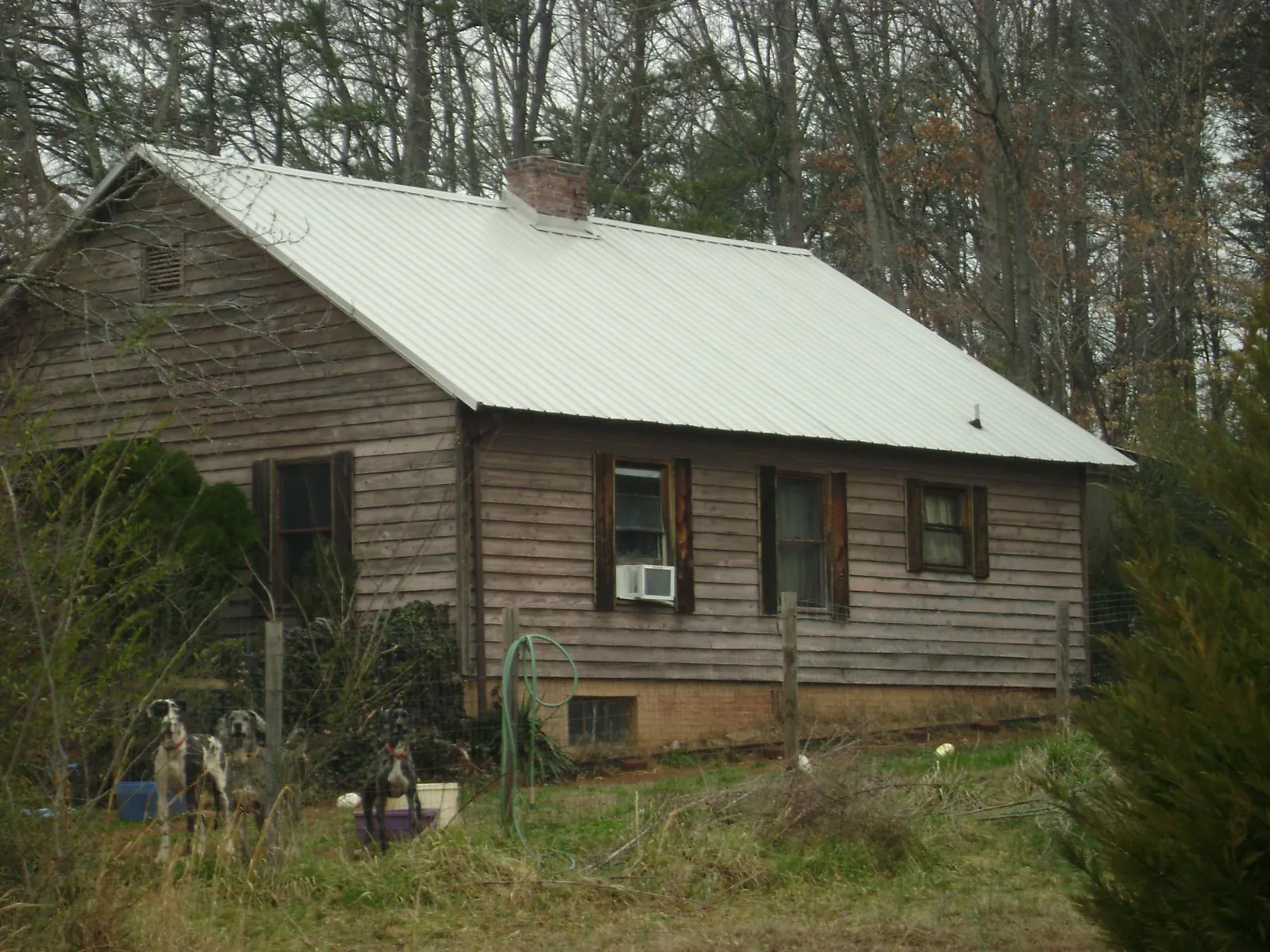 White metal roof on an old wood sided farmhouse, from a Metal Roof Installation job in Larimore